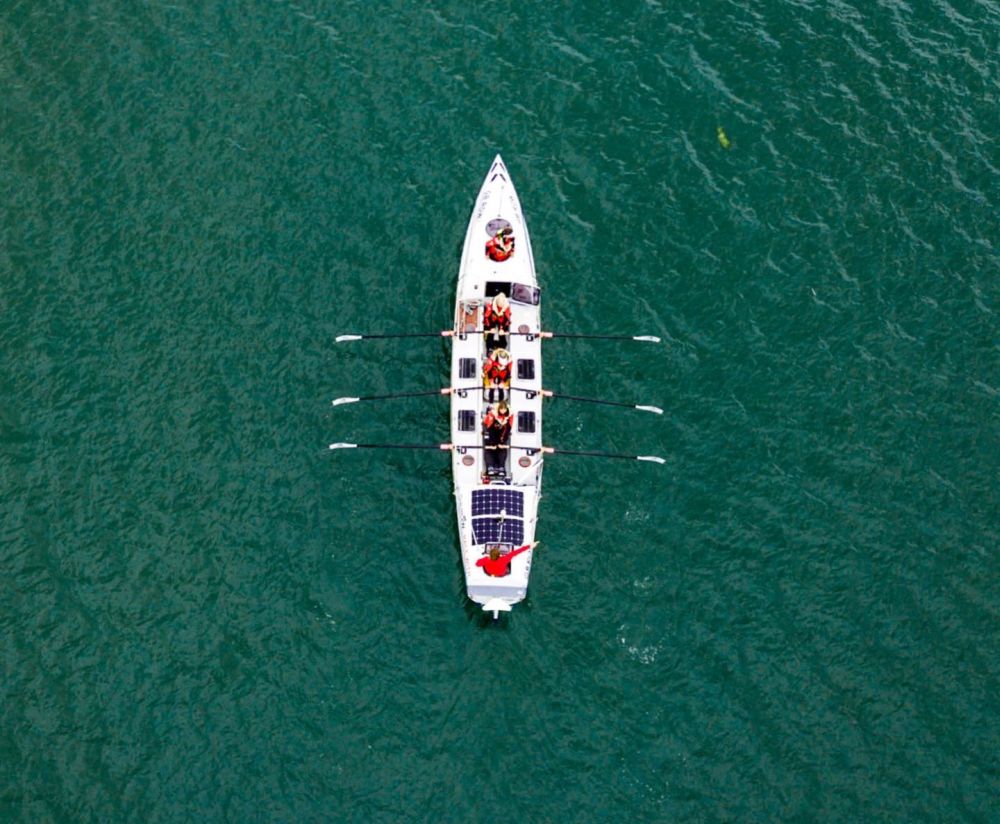 A picture of one of the ocean rowing boats on the sea taken by a drone in the sky